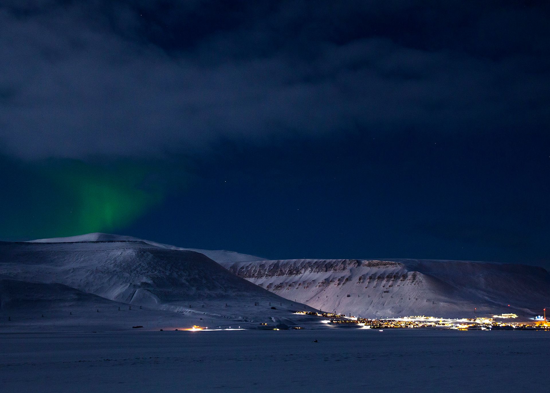 Svake nordlys som skinner over Longyearbyen