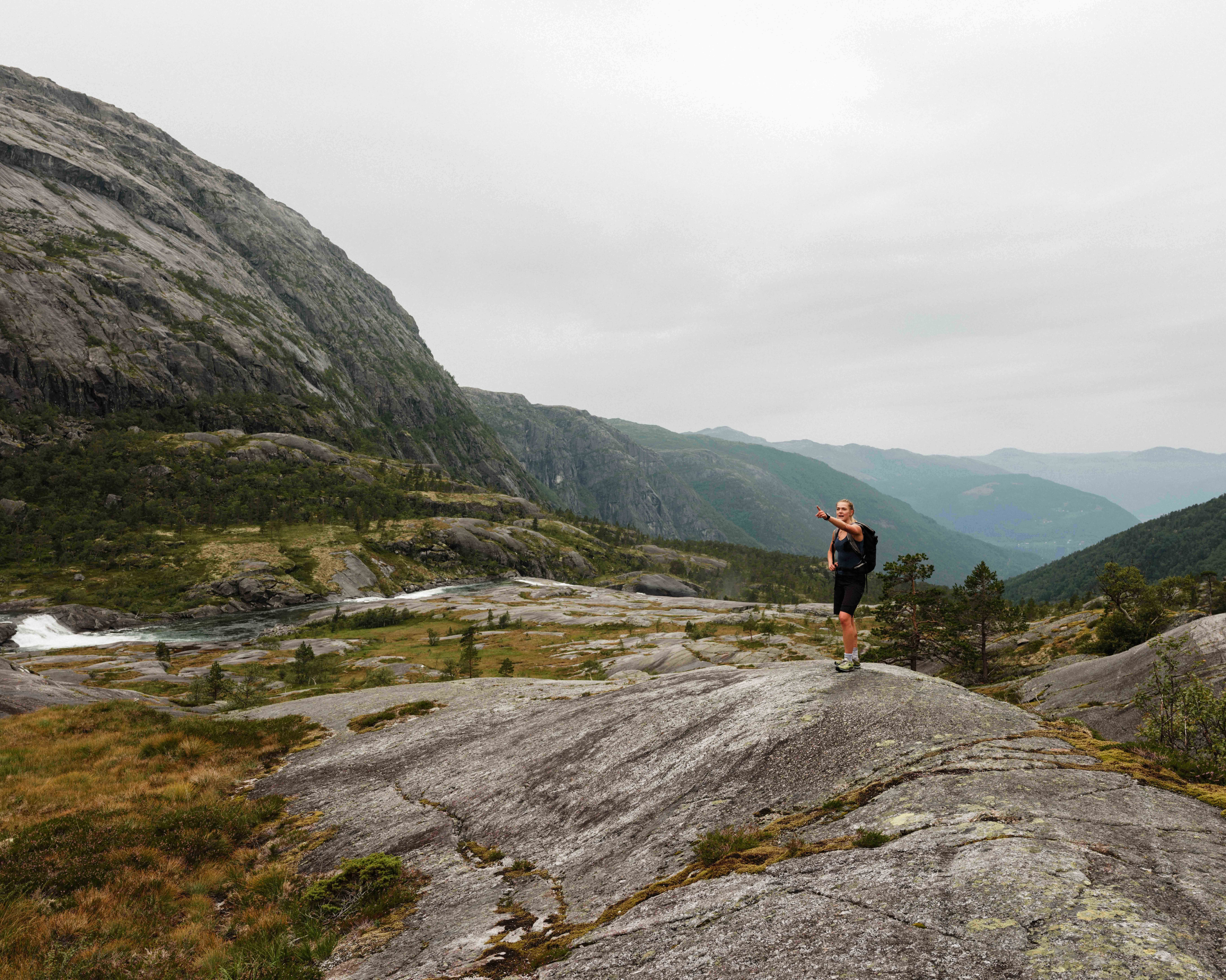 Turgåar ser utover fjordlandskapet på veg opp Husedalen – spektakulær utsikt mot Hardanger.