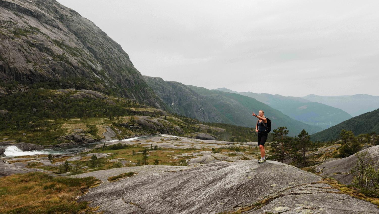Turgåar ser utover fjordlandskapet på veg opp Husedalen – spektakulær utsikt mot Hardanger.
