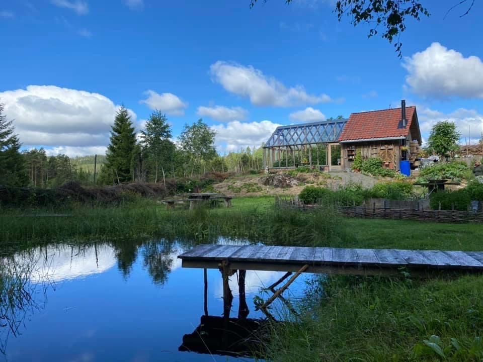 et lite gårdshus ved vannet som blir bygget på