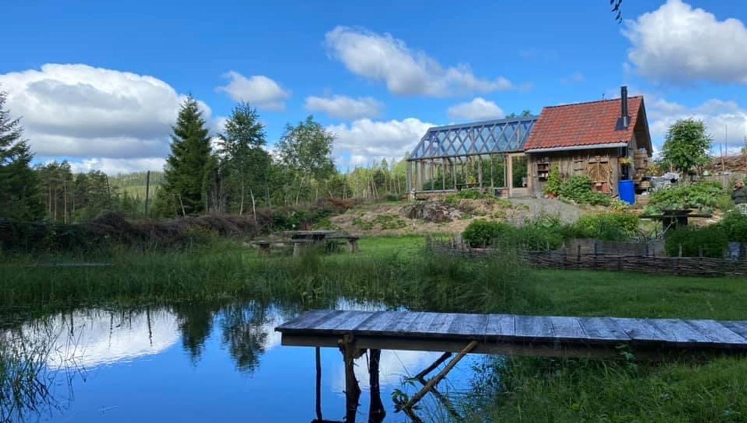 et lite gårdshus ved vannet som blir bygget på