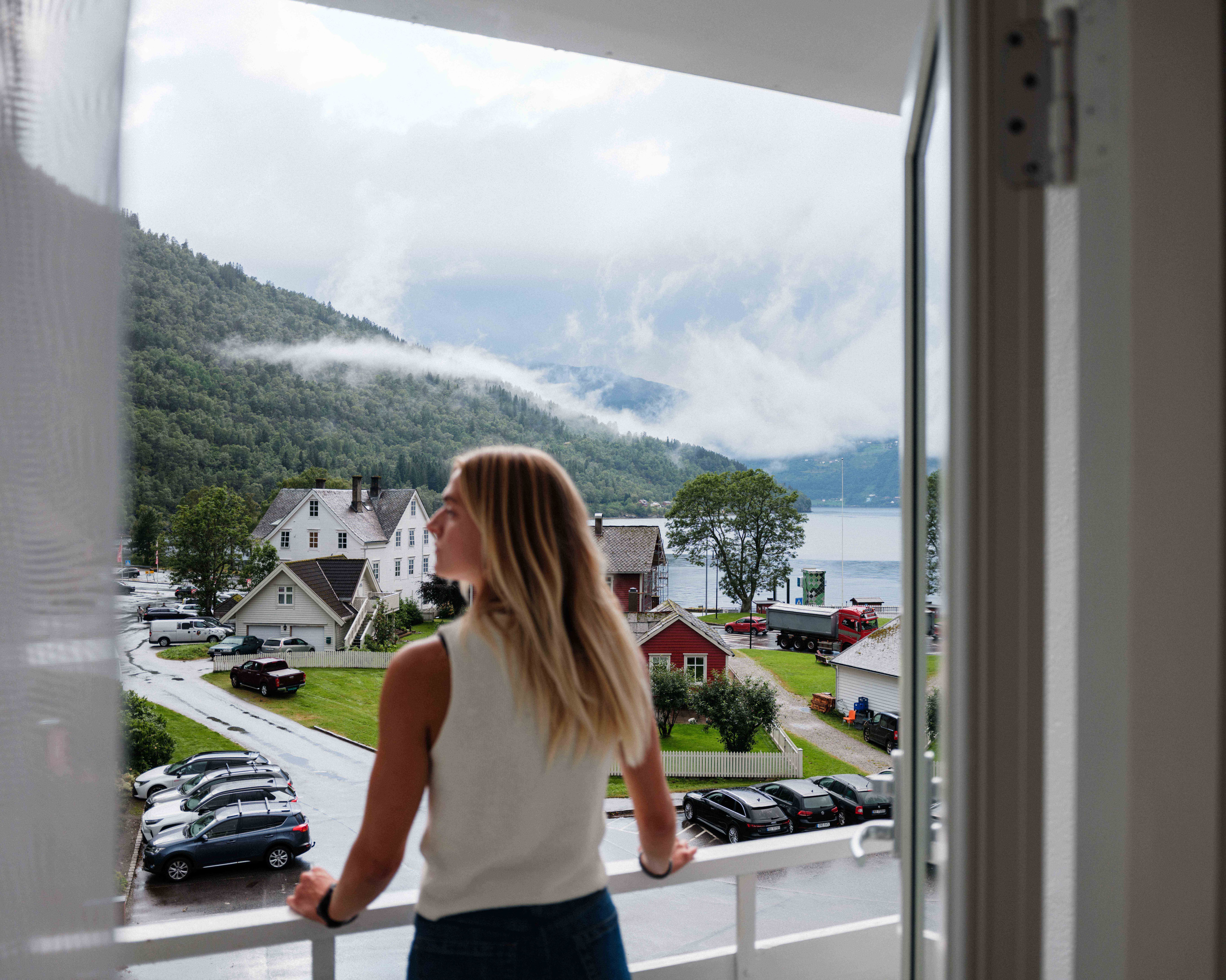 Utsikt frå balkongen på Kinsarvik Fjordhotel med fjorden og Kinsarvik sentrum i bakgrunnen.