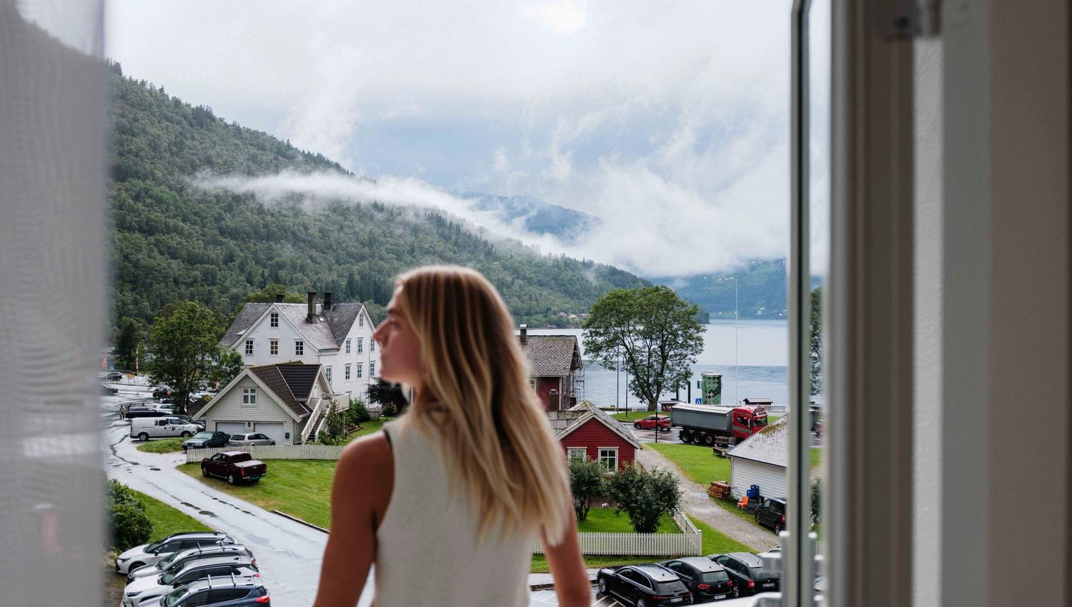 Utsikt frå balkongen på Kinsarvik Fjordhotel med fjorden og Kinsarvik sentrum i bakgrunnen.