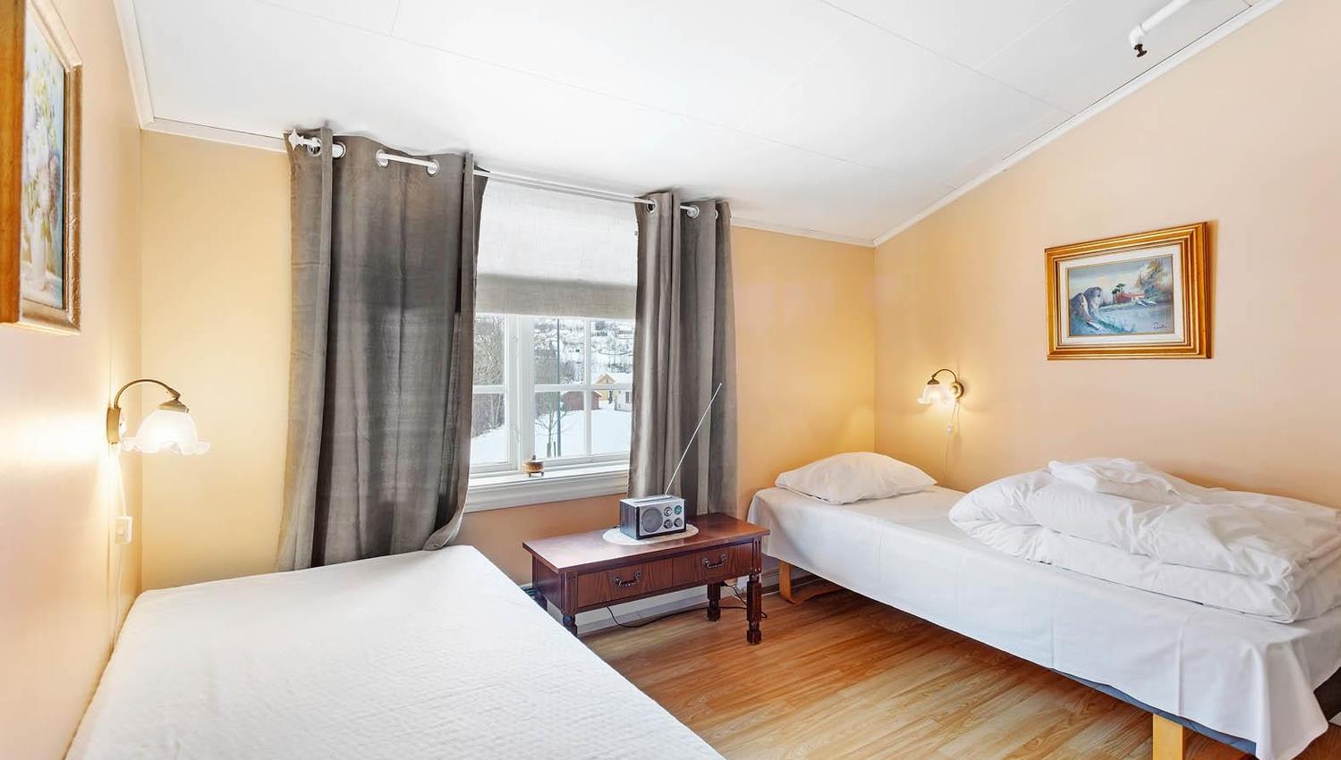 Bright twin bedroom with village view at Jaunsen Guesthouse in Hardanger.