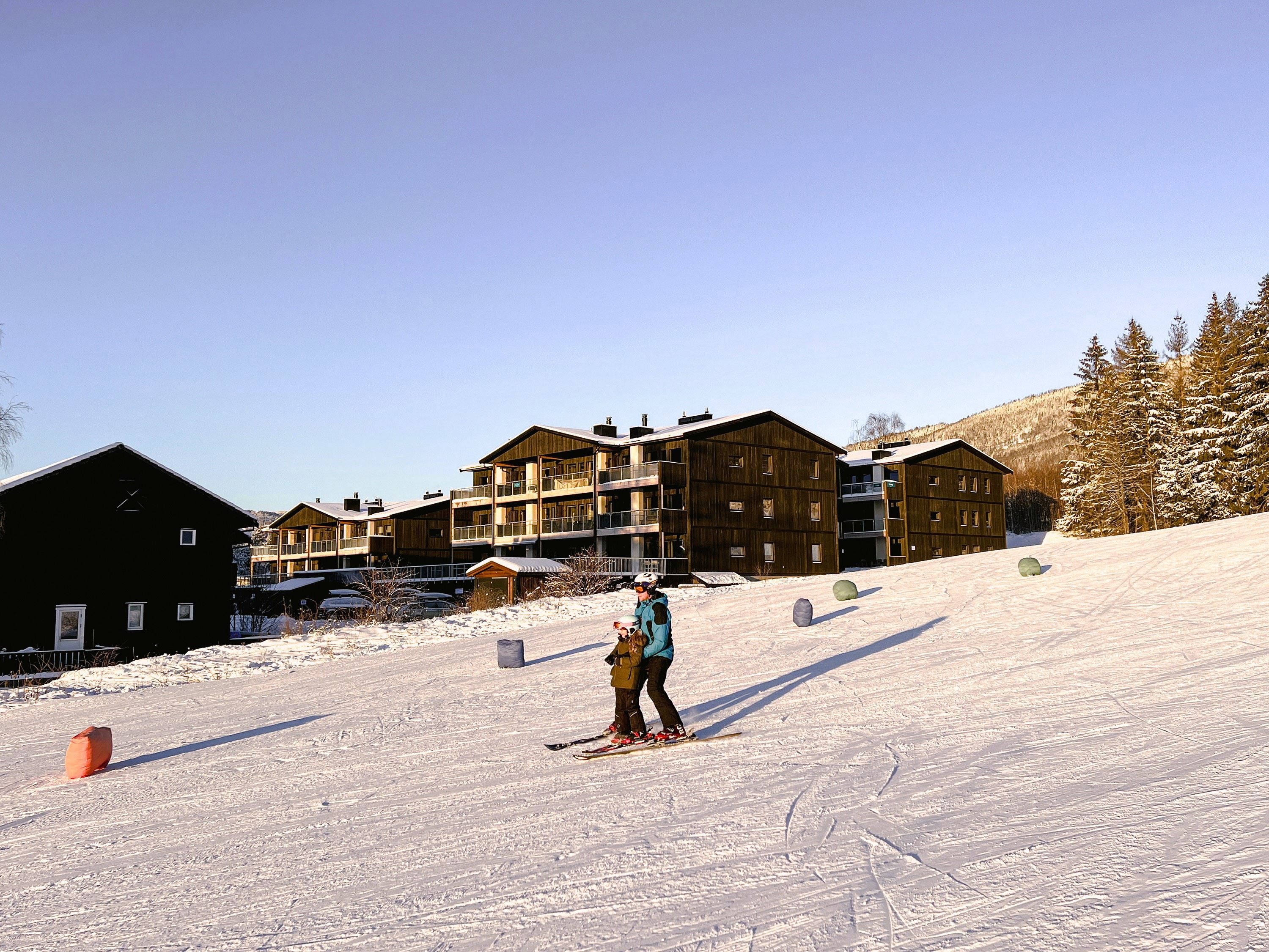 A person and a child skiing in the snow.