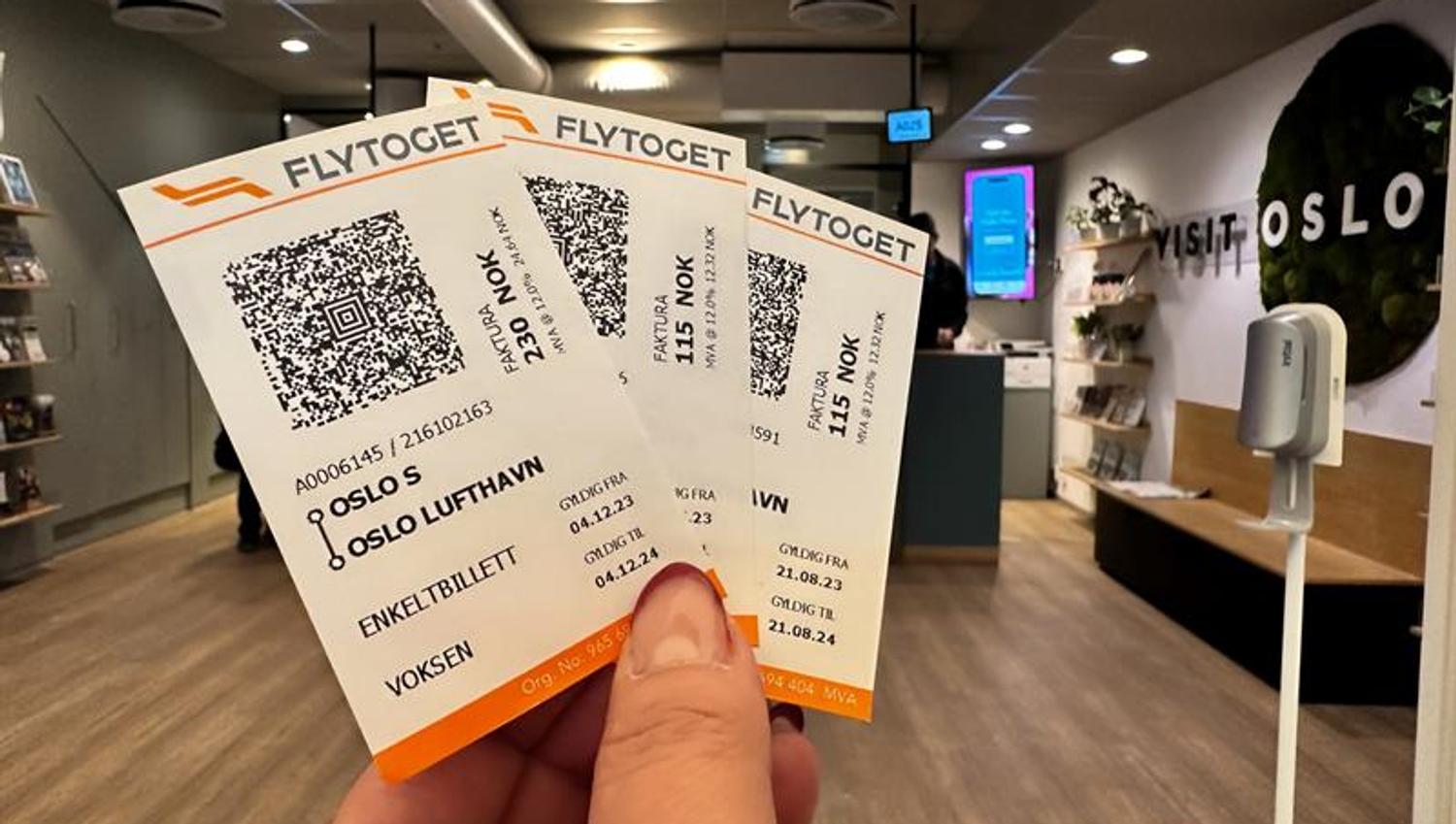 Detalj av hånd som holder tre billetter for flytoget