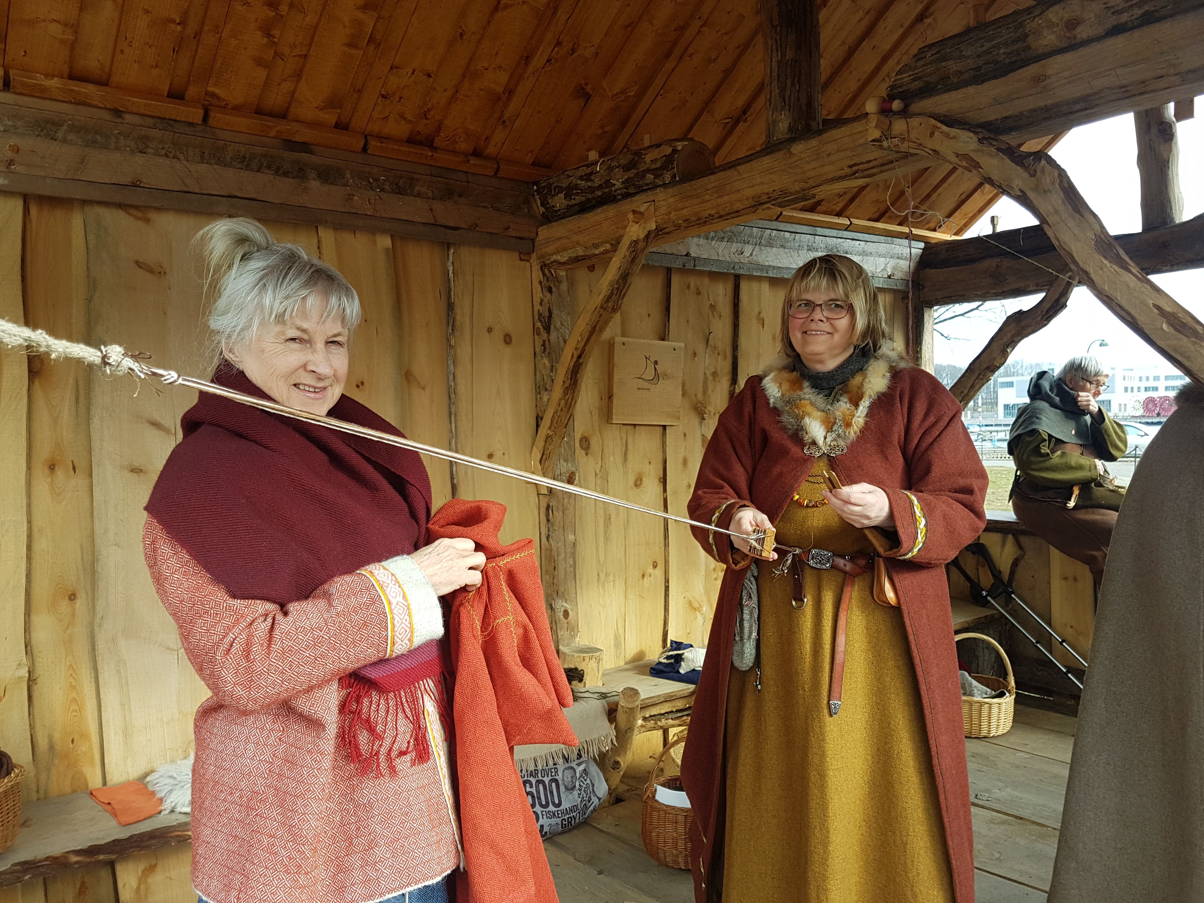 Bilde av to kvinner i vikingklær som viser noen av viking aktivitetene på Vikingodden