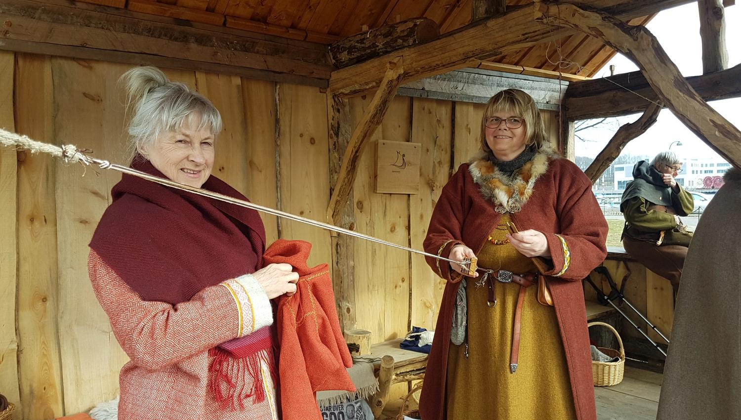 Bilde av to kvinner i vikingklær som viser noen av viking aktivitetene på Vikingodden