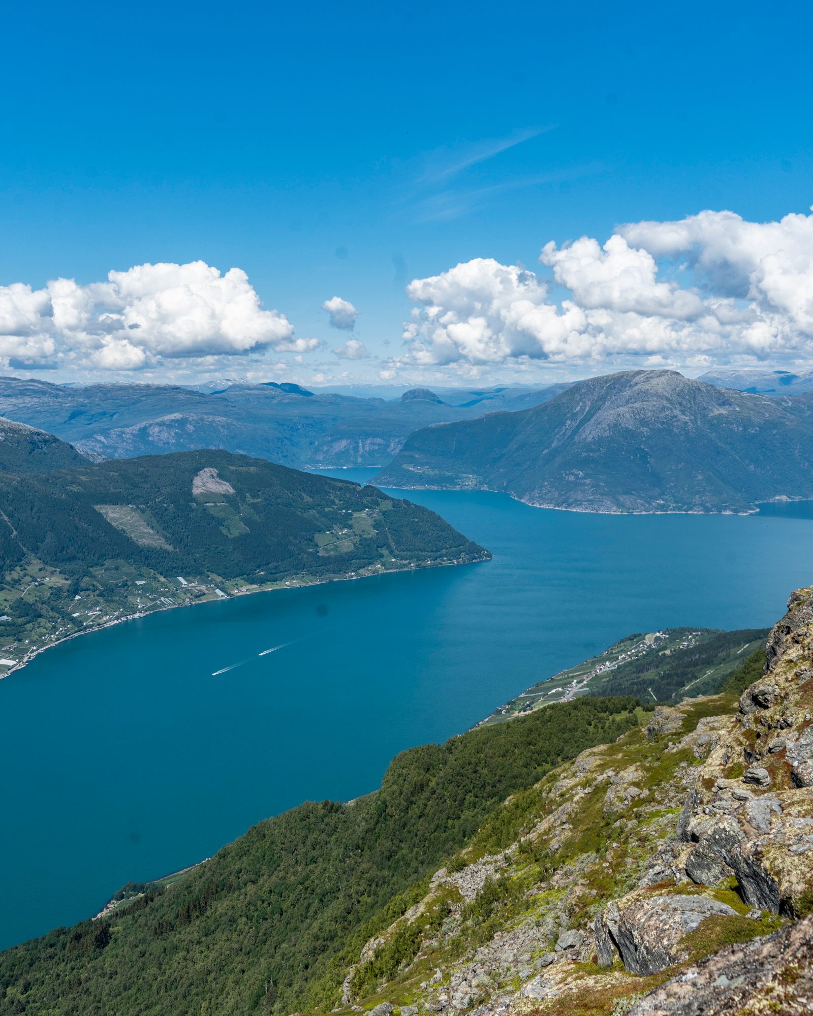 Panoramic view over the Hardangerfjord seen from Dronningstien under a clear, blue sky.