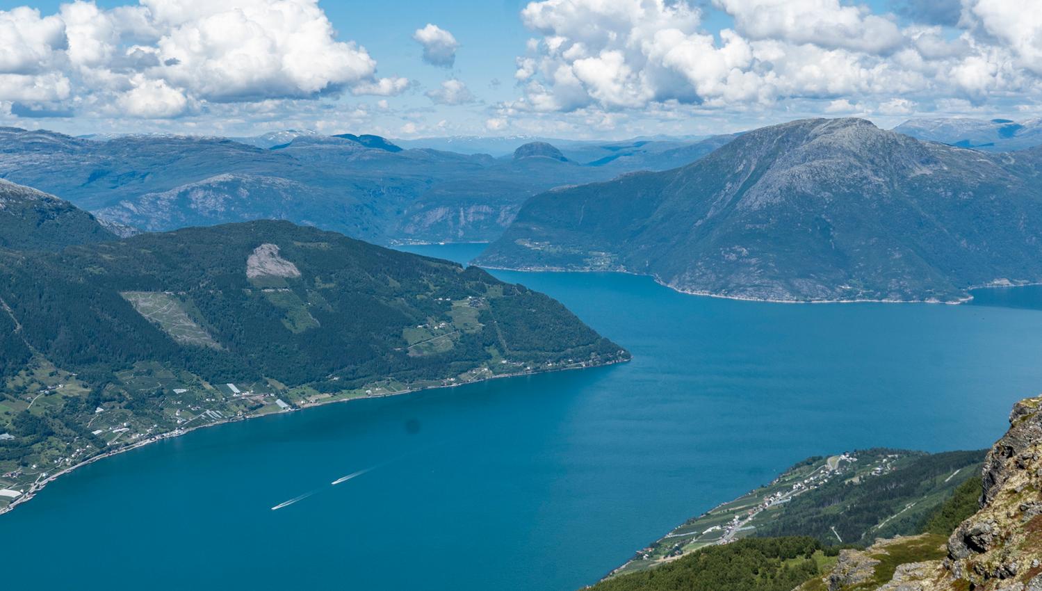 Panoramic view over the Hardangerfjord seen from Dronningstien under a clear, blue sky.