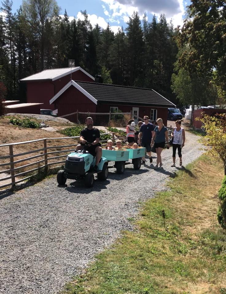 Small tractor with trailer and visitors