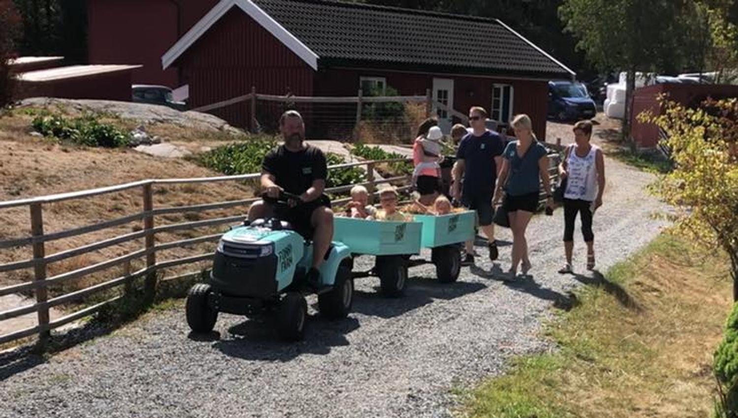 Small tractor with trailer and visitors