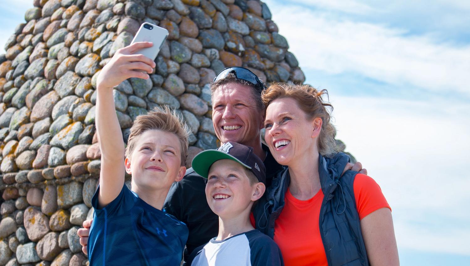 Family takes a selfie at the tilting lighthouse at the End of the World