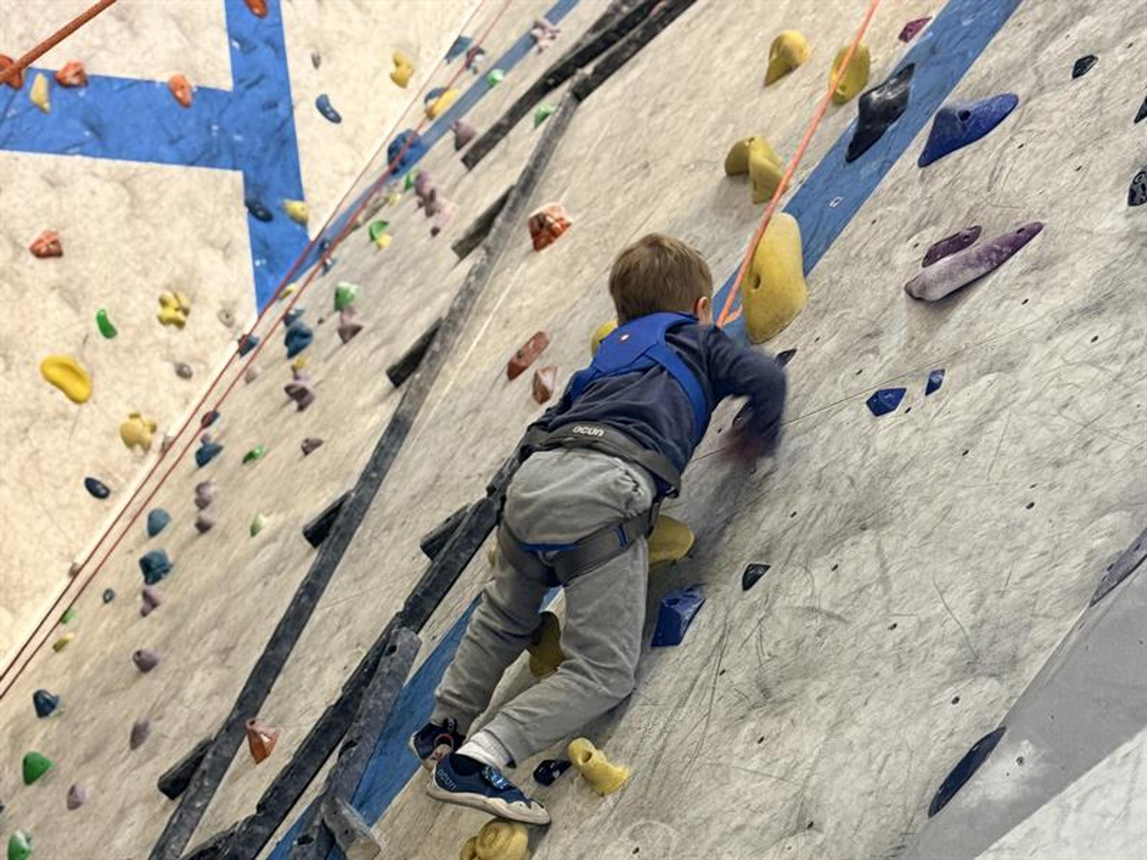a child climbing at a clmbing-wall