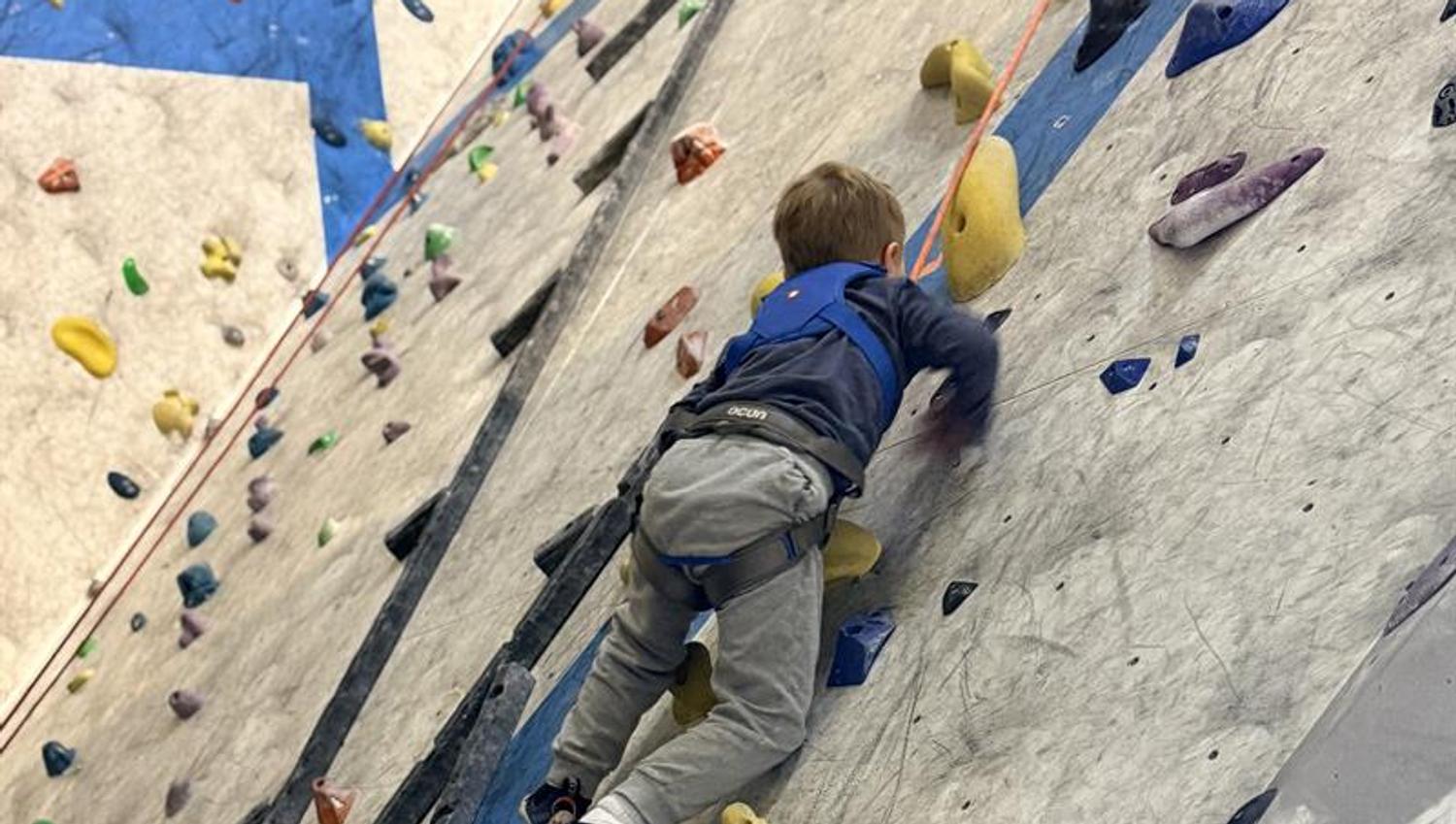 a child climbing at a clmbing-wall
