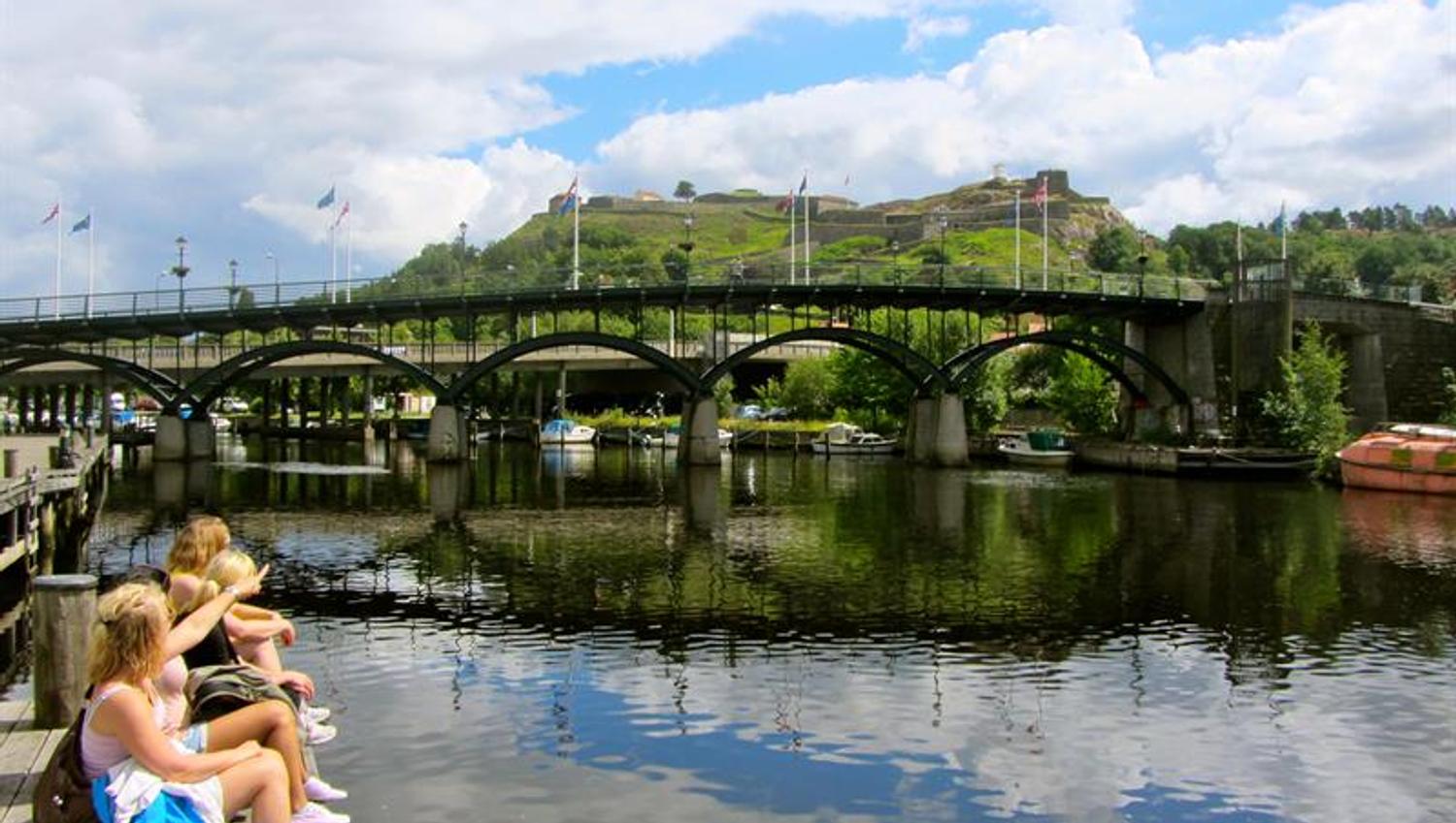 Utsikt fra Fiskebrygga i Halden, Fredriksten festning og gangbrua speiler seg i Tista-elva