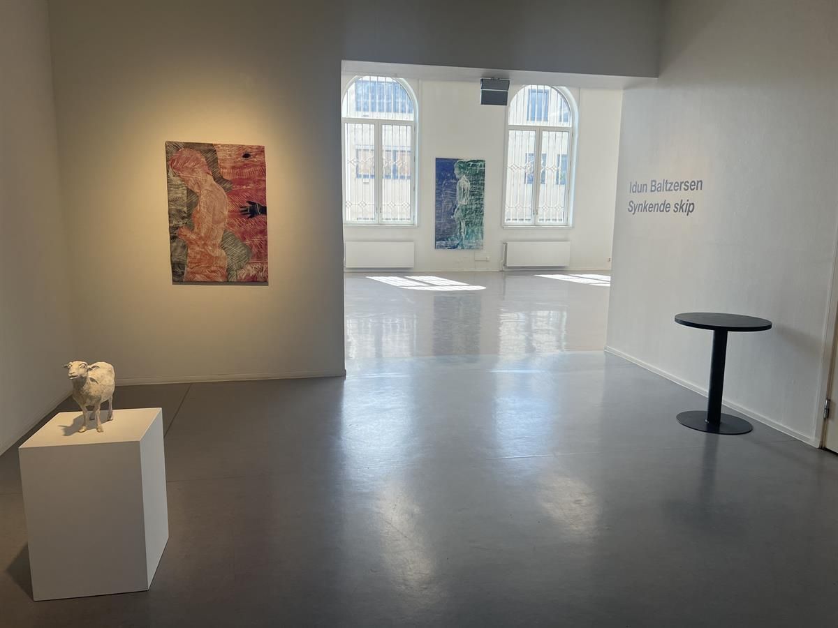 Moderne utstillingsrom med kunstverk på veggene.