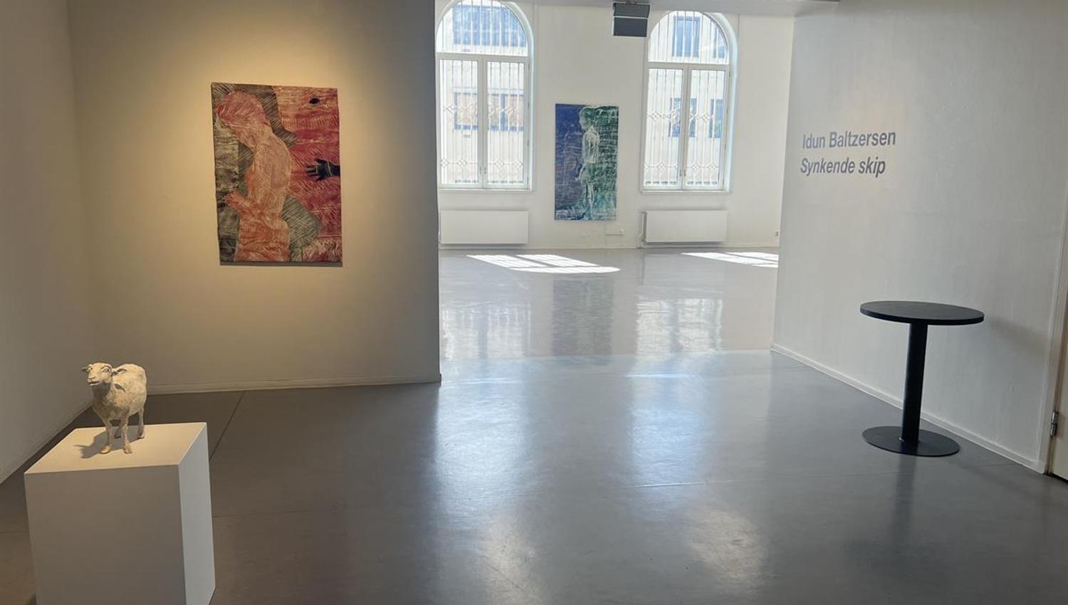 Moderne utstillingsrom med kunstverk på veggene.
