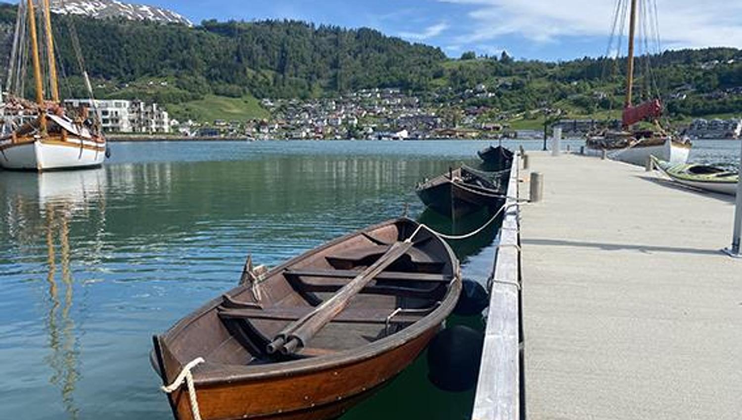 Rowboats docked at the pier at Hardanger Maritime Center.