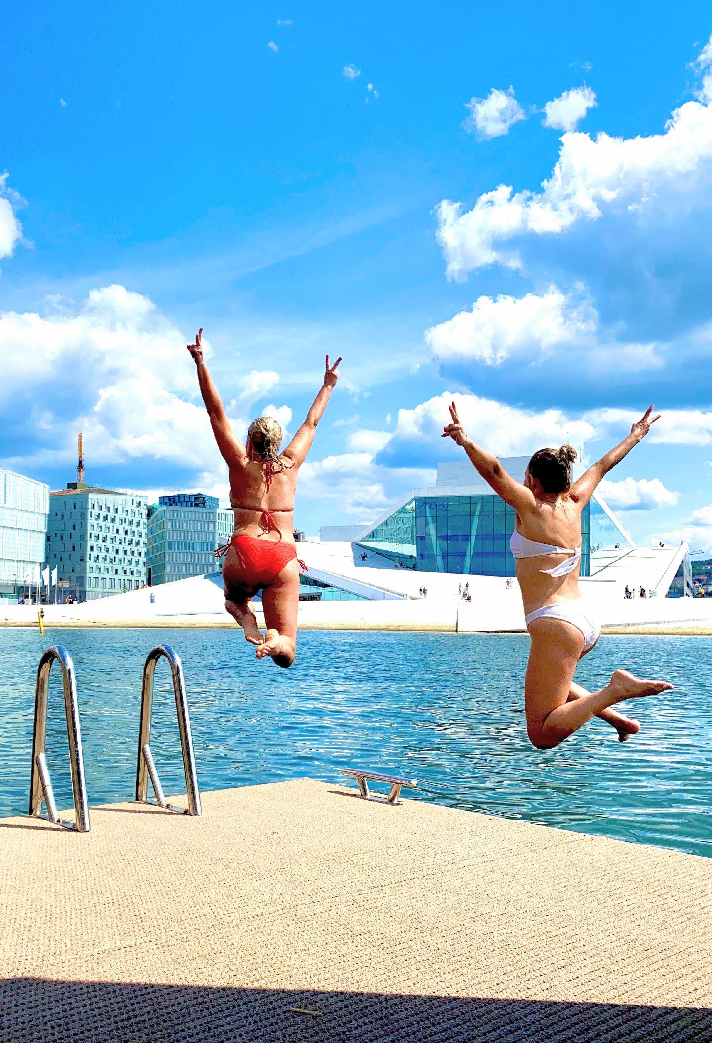 To jenter som hopper ut i vannet foran operaen.