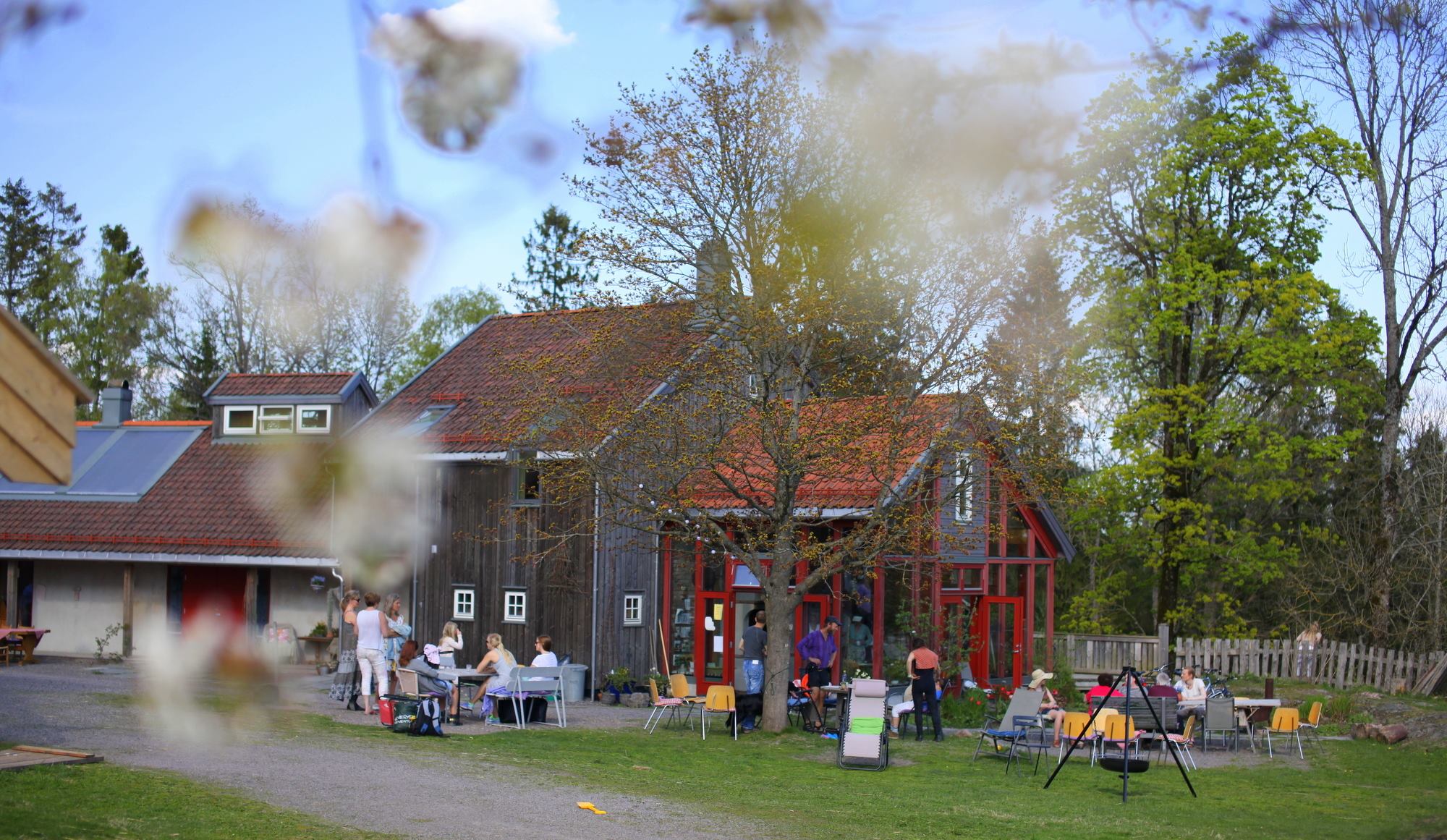 Farmhouse with house, green garden, trees and people