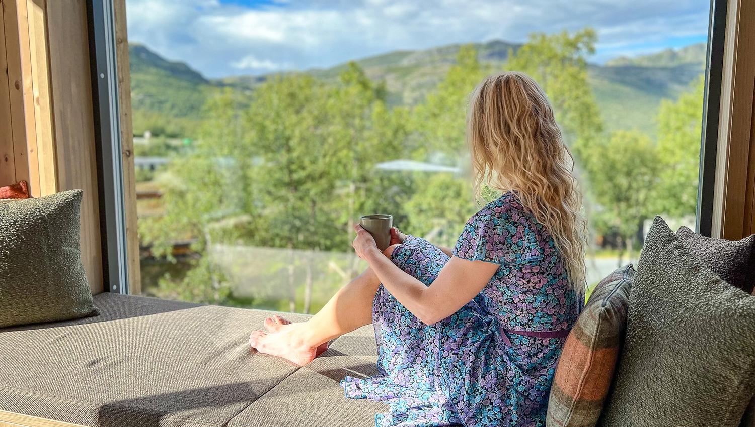 Kvinne nyter utsikt fra hotellrom