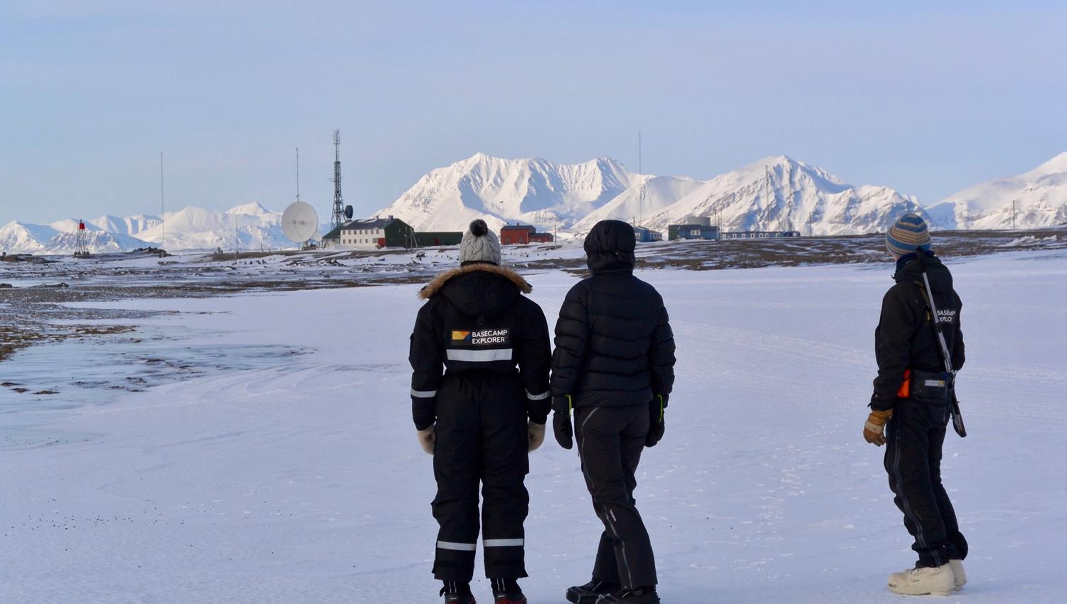 Guests and a guide looking towards Isfjord Radio