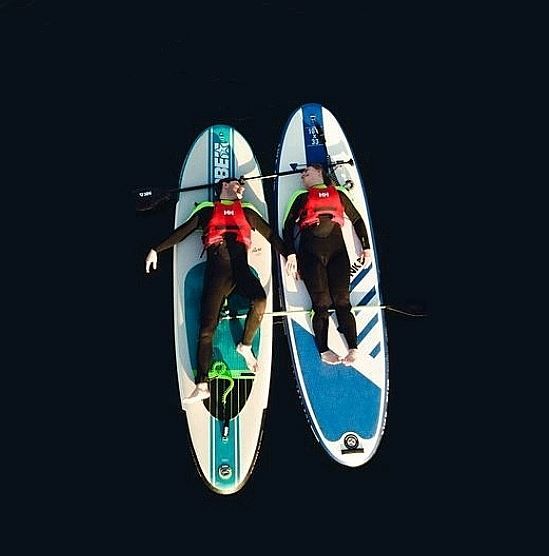two people lying on a wakeboard relaxing