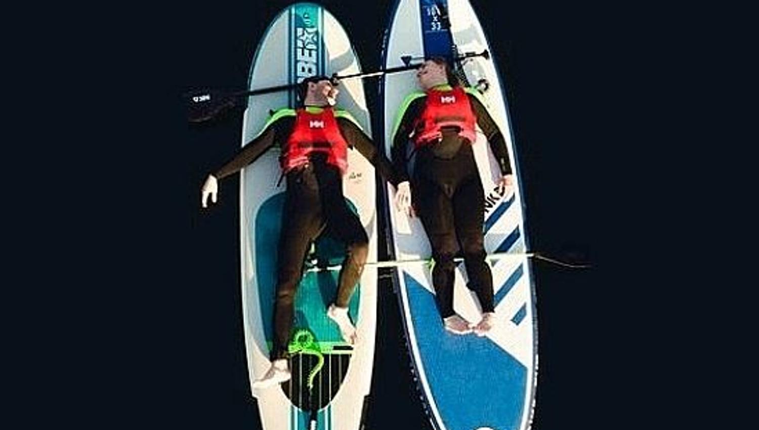 two people lying on a wakeboard relaxing