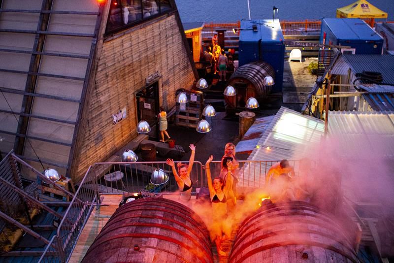 The barrel saunas with a group of people in front 