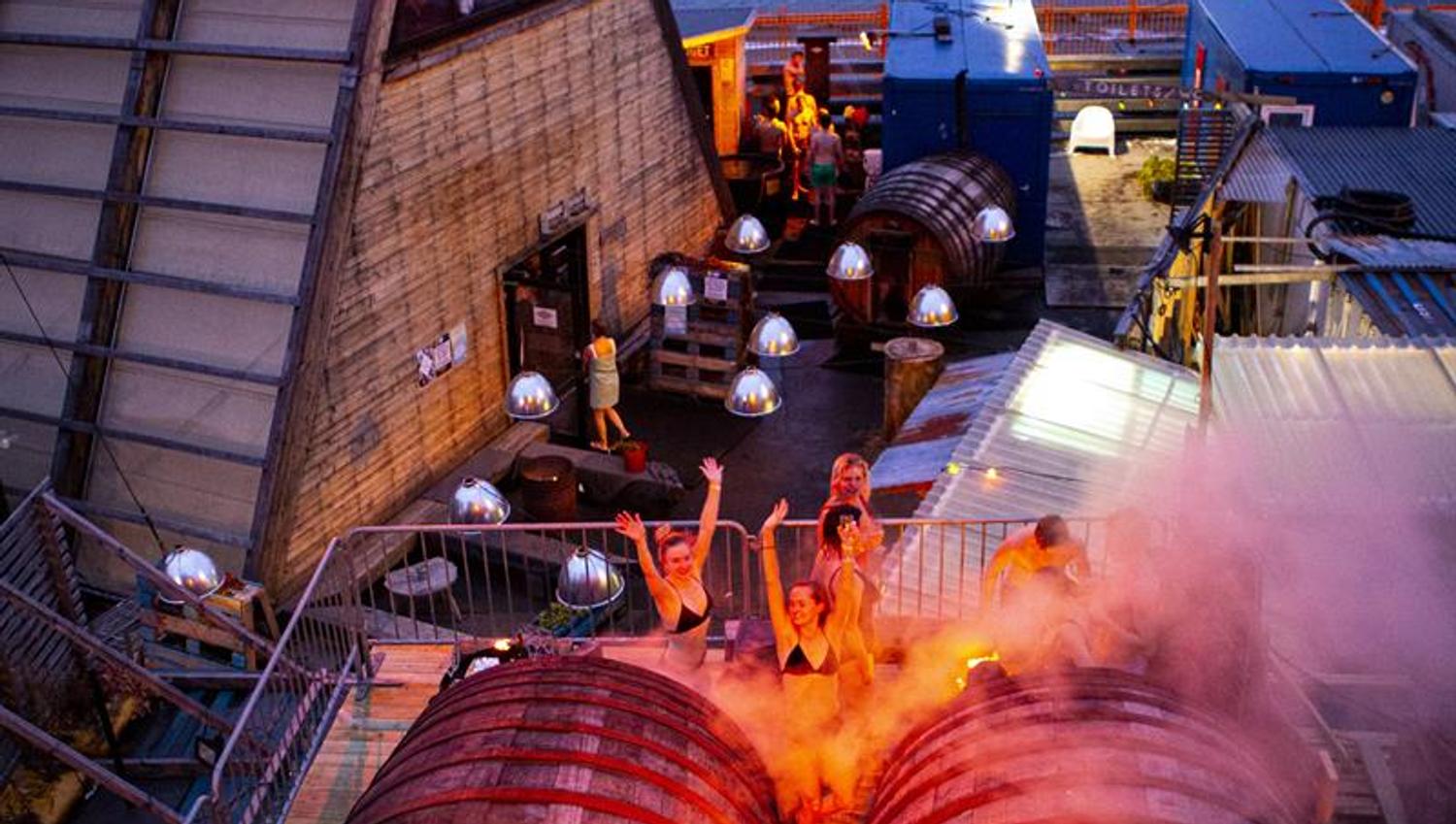 The barrel saunas with a group of people in front
