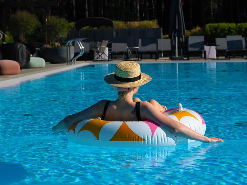 Utebasseng sommer The Well, dame med solhatt på badering