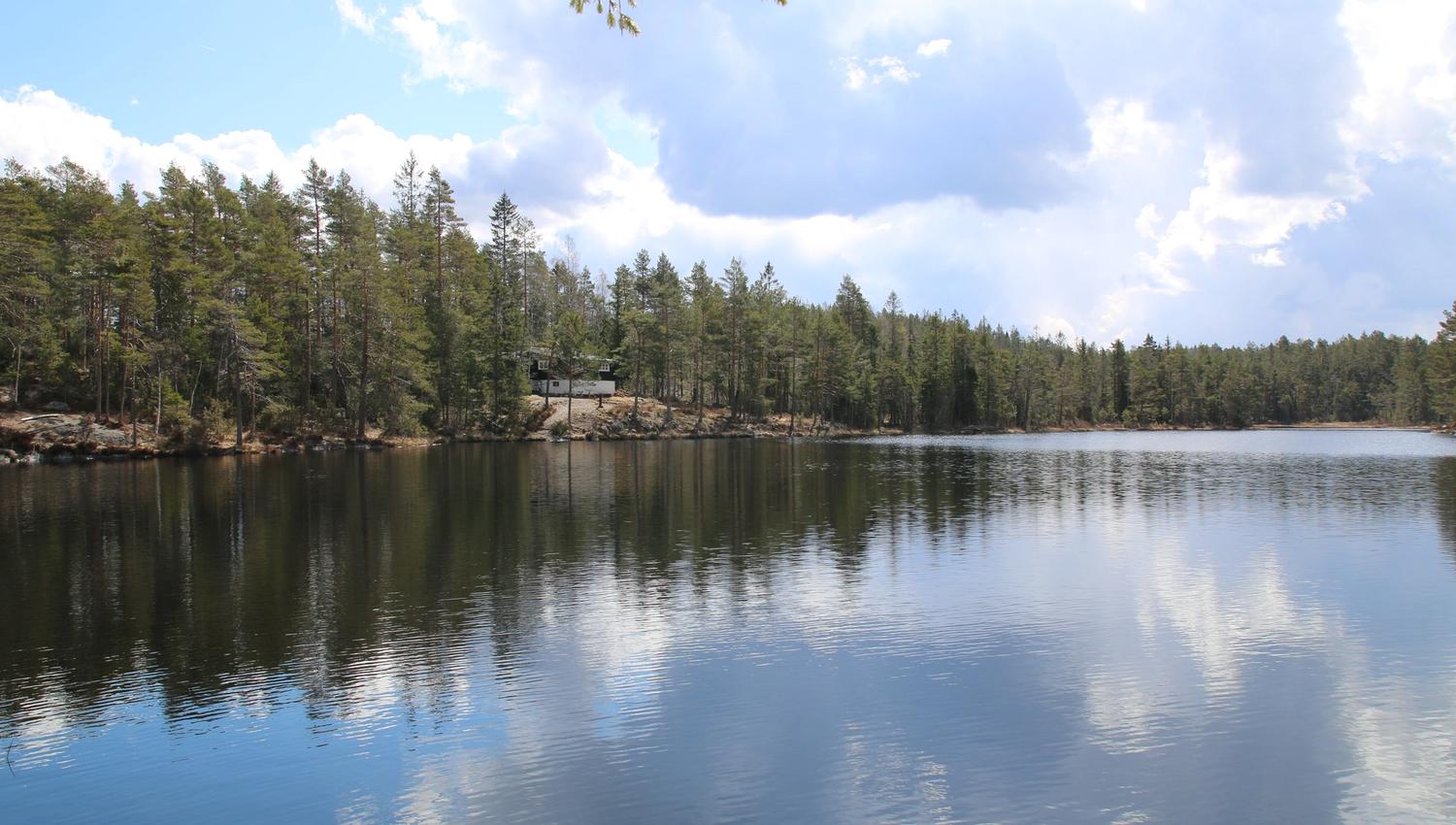 utsikt over stille tjern og hytte