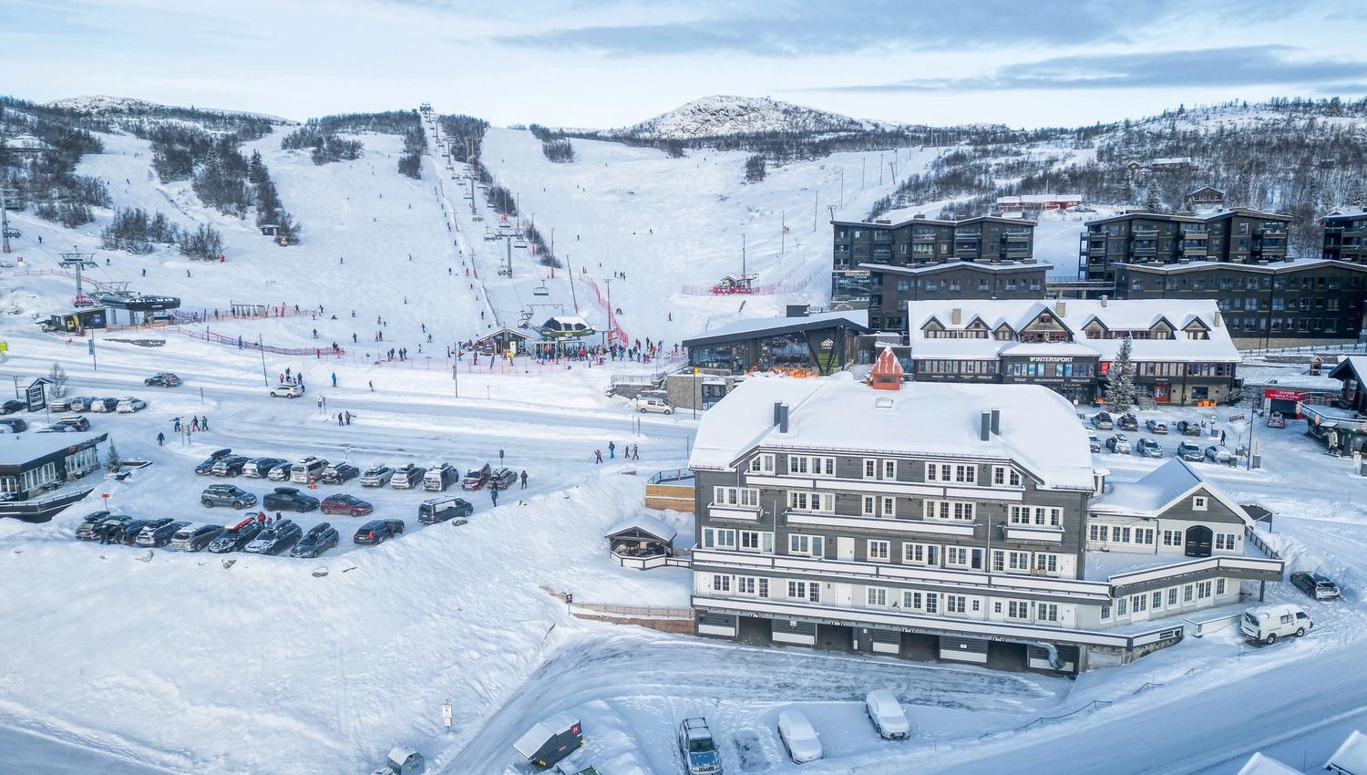 Dronefoto Gjestegaarden med alpinsenter bak, dagtid.