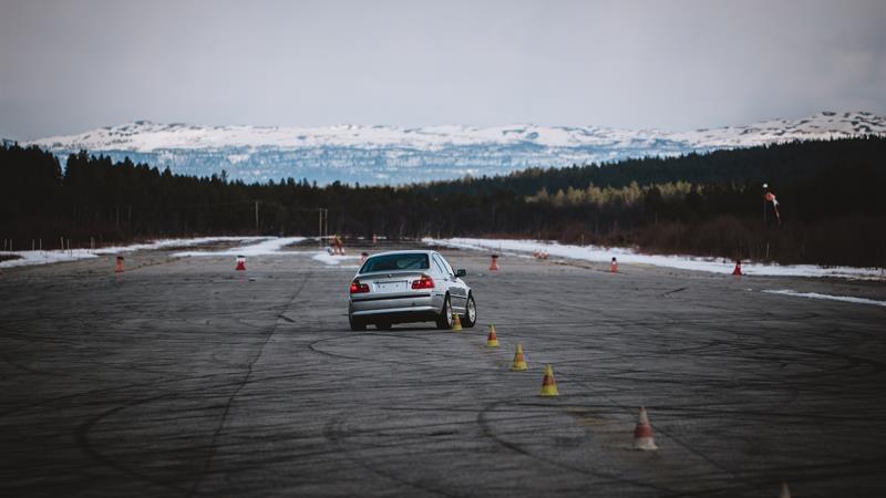 A car during the race and mountains on the background. 