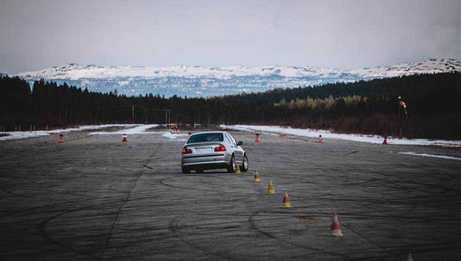 A car during the race and mountains on the background.