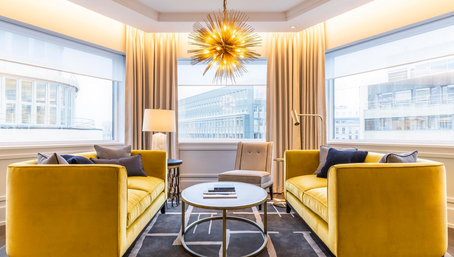 To gule sofaer foran vindu. Stjerneformet taklampe. Hotel Continental, Oslo. foto