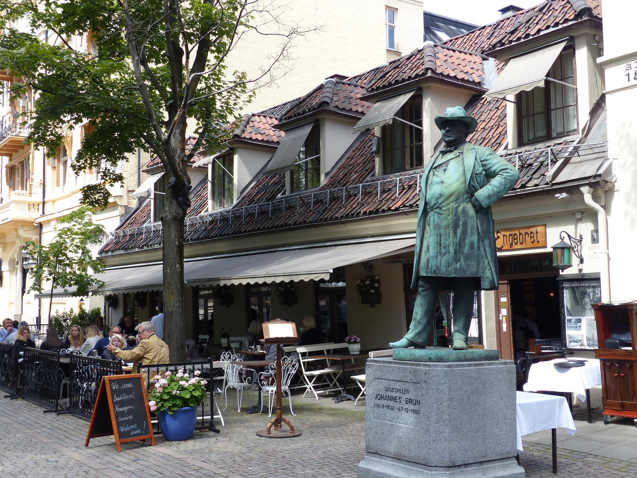 Exterior with outdoor seating next to a statue.