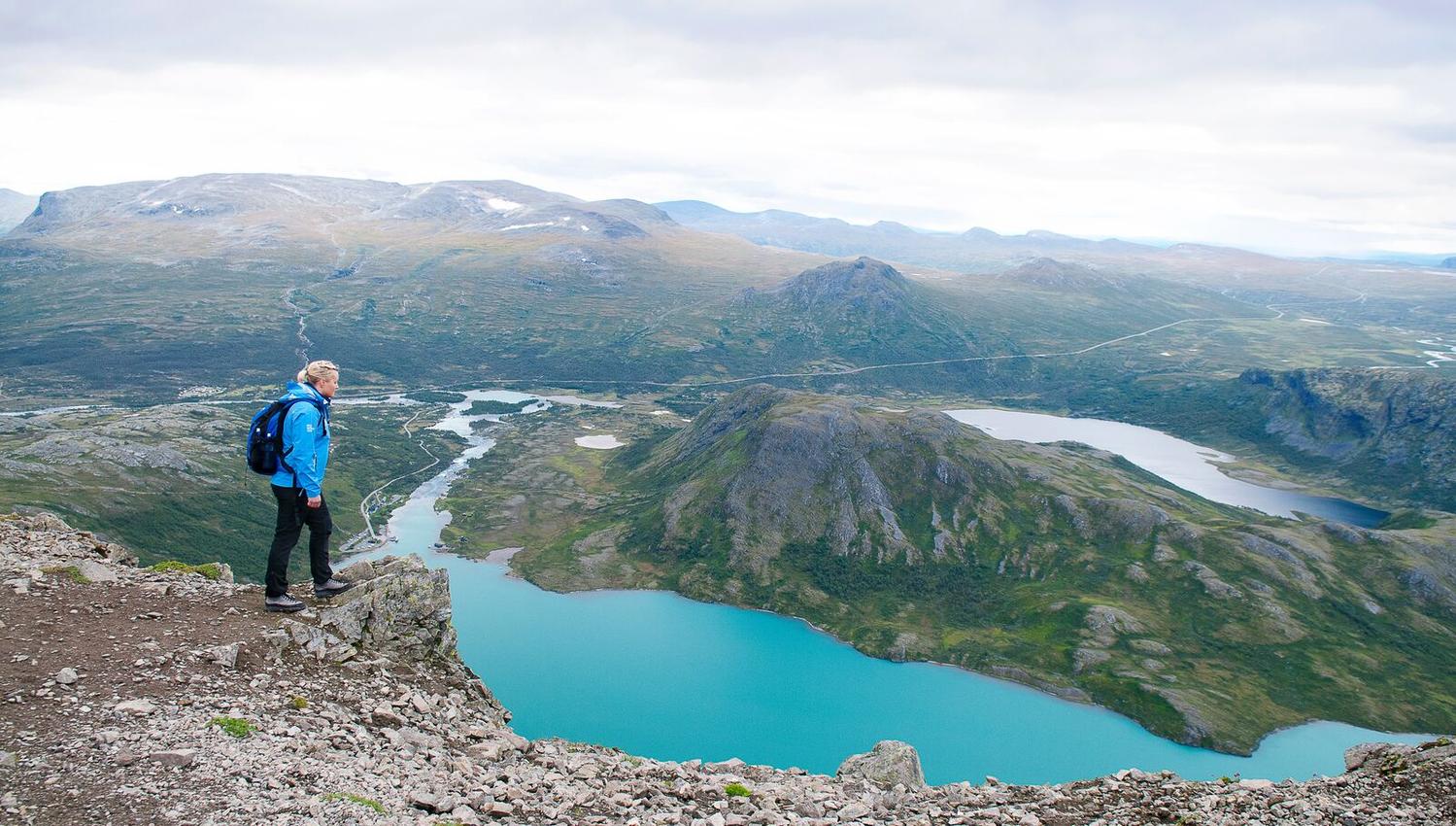 Turgåer på toppen av Besseggen. Utsikt mot fjell og fjord.