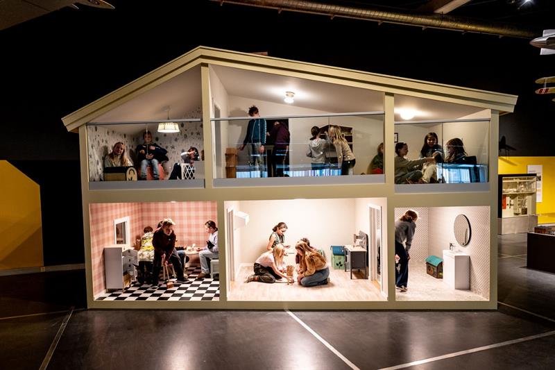 Detalj av dukkehus i naturlig størrelse med ekte mennesker i utstillingen "Modeller og miniatyrer"