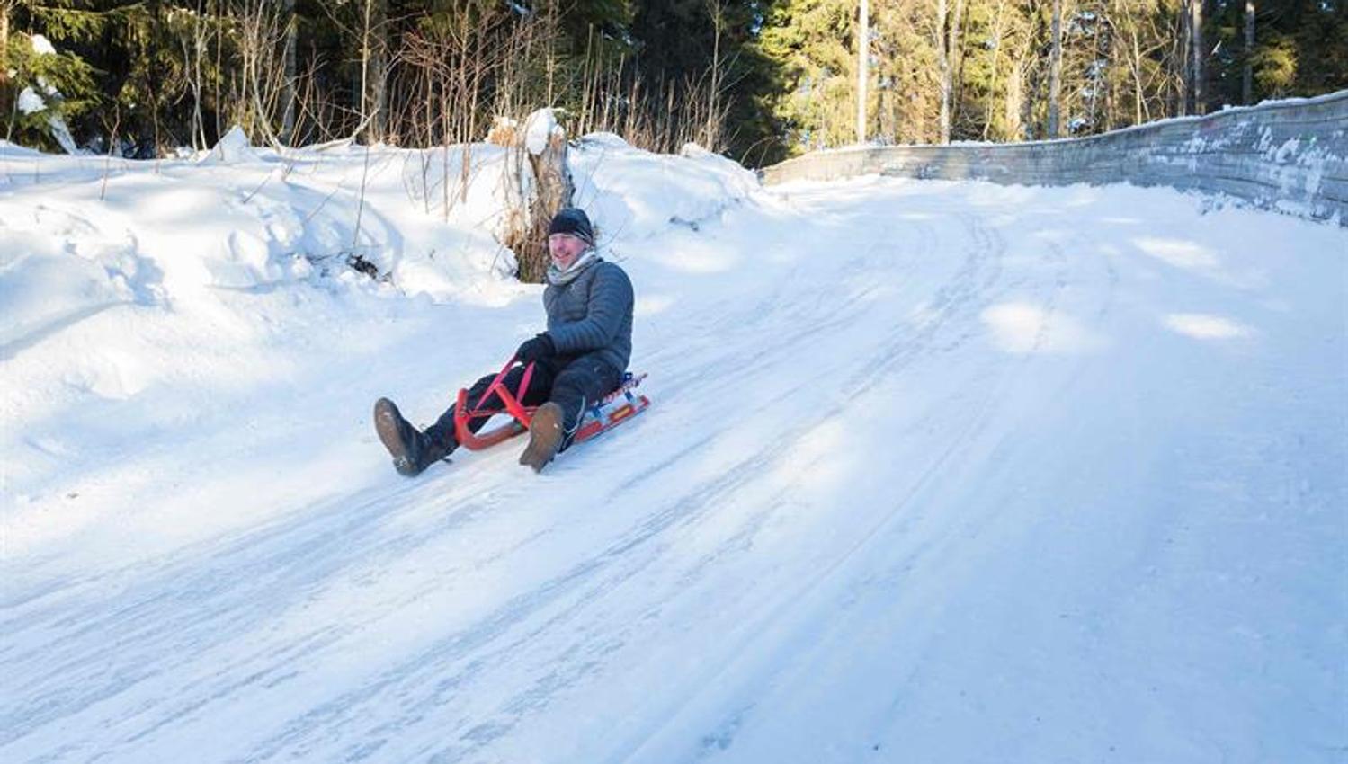 En person som aker ned en snødekt bakke.