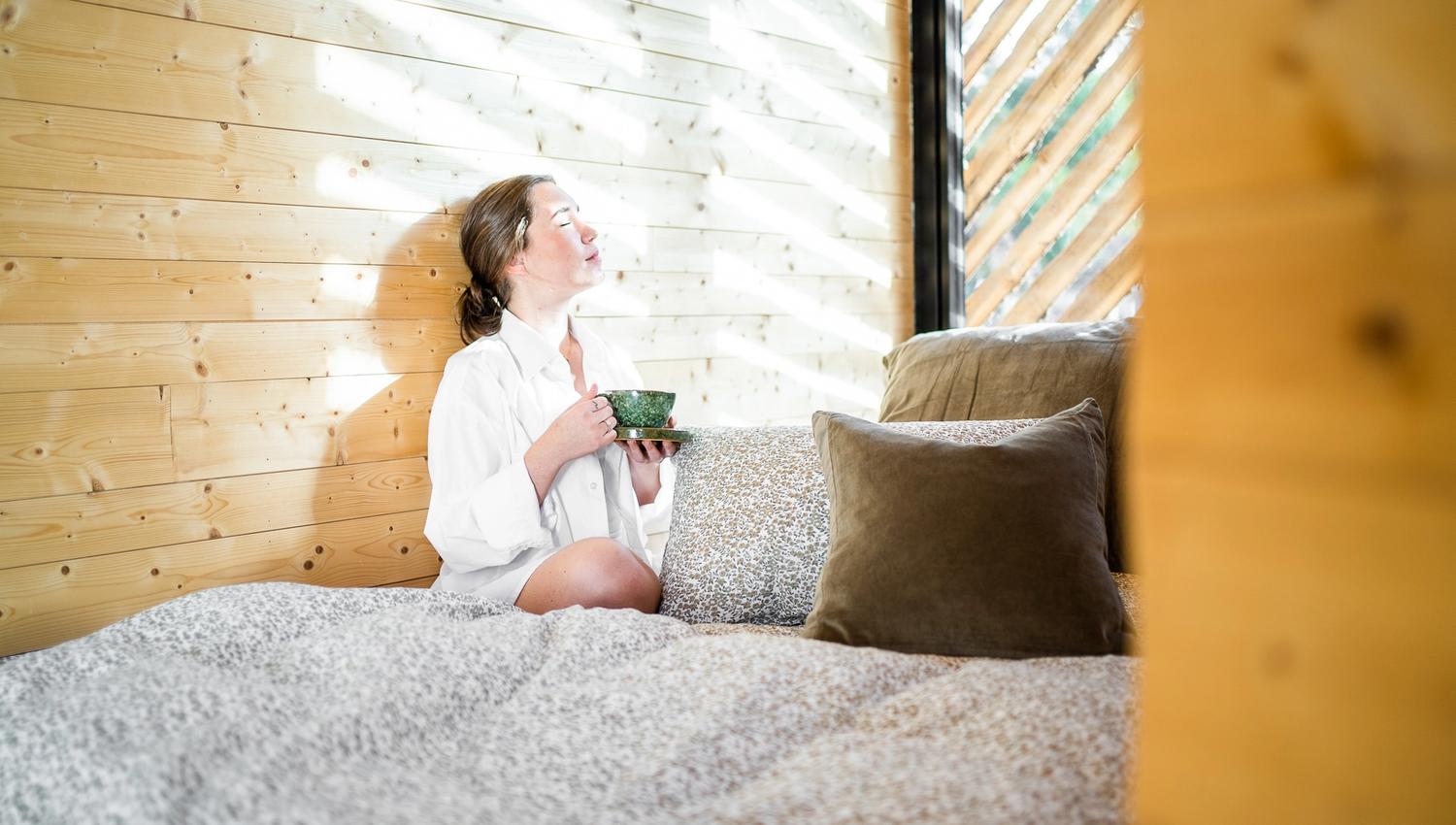 Dame nyter solen med kaffe