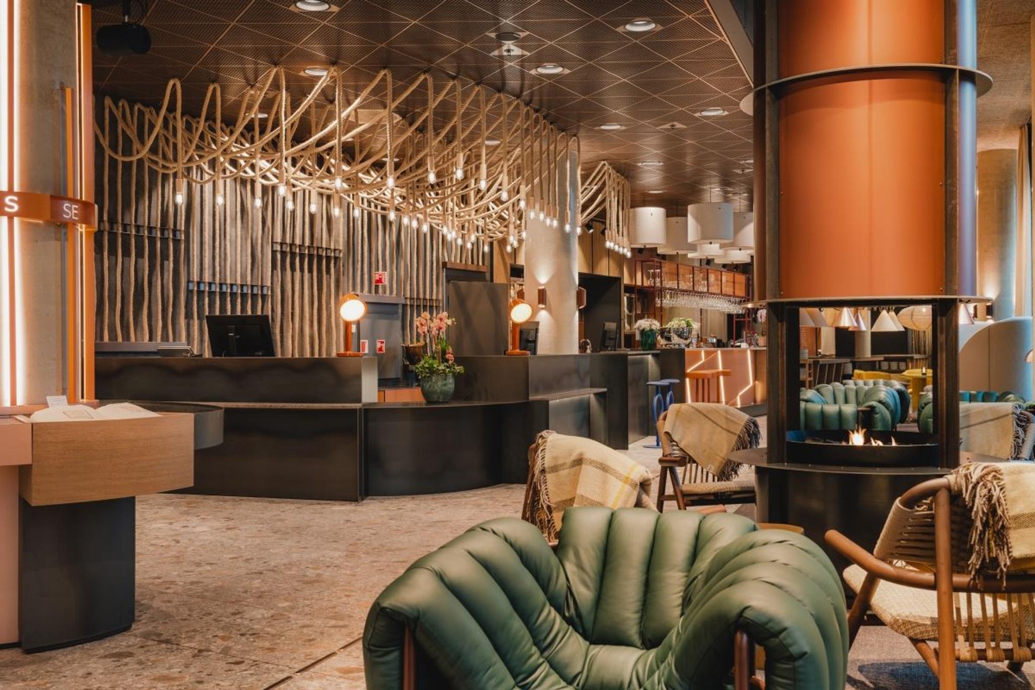 Modern hotel lobby with reception desk, seating areas, and decorative lighting