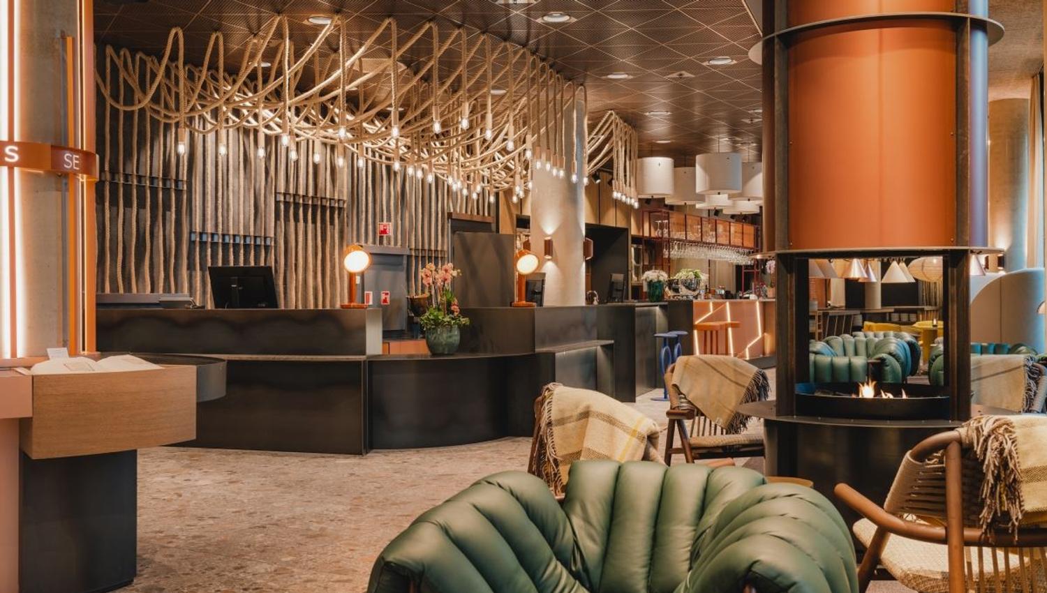 Modern hotel lobby with reception desk, seating areas, and decorative lighting