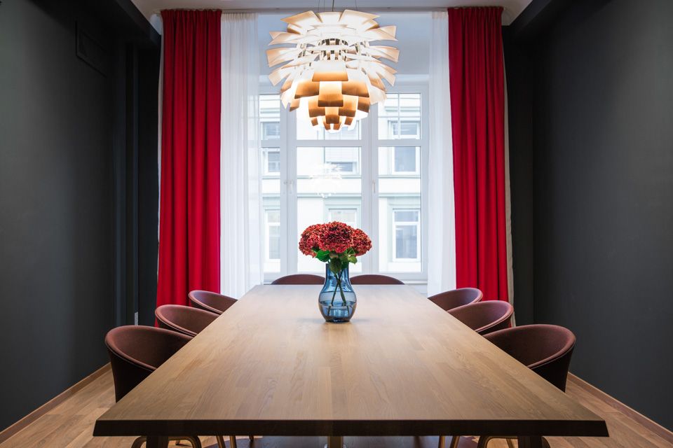 Meeting room with eight chairs. Red curtains, red flowers. Hotell Bondeheimen, Oslo. Photo
