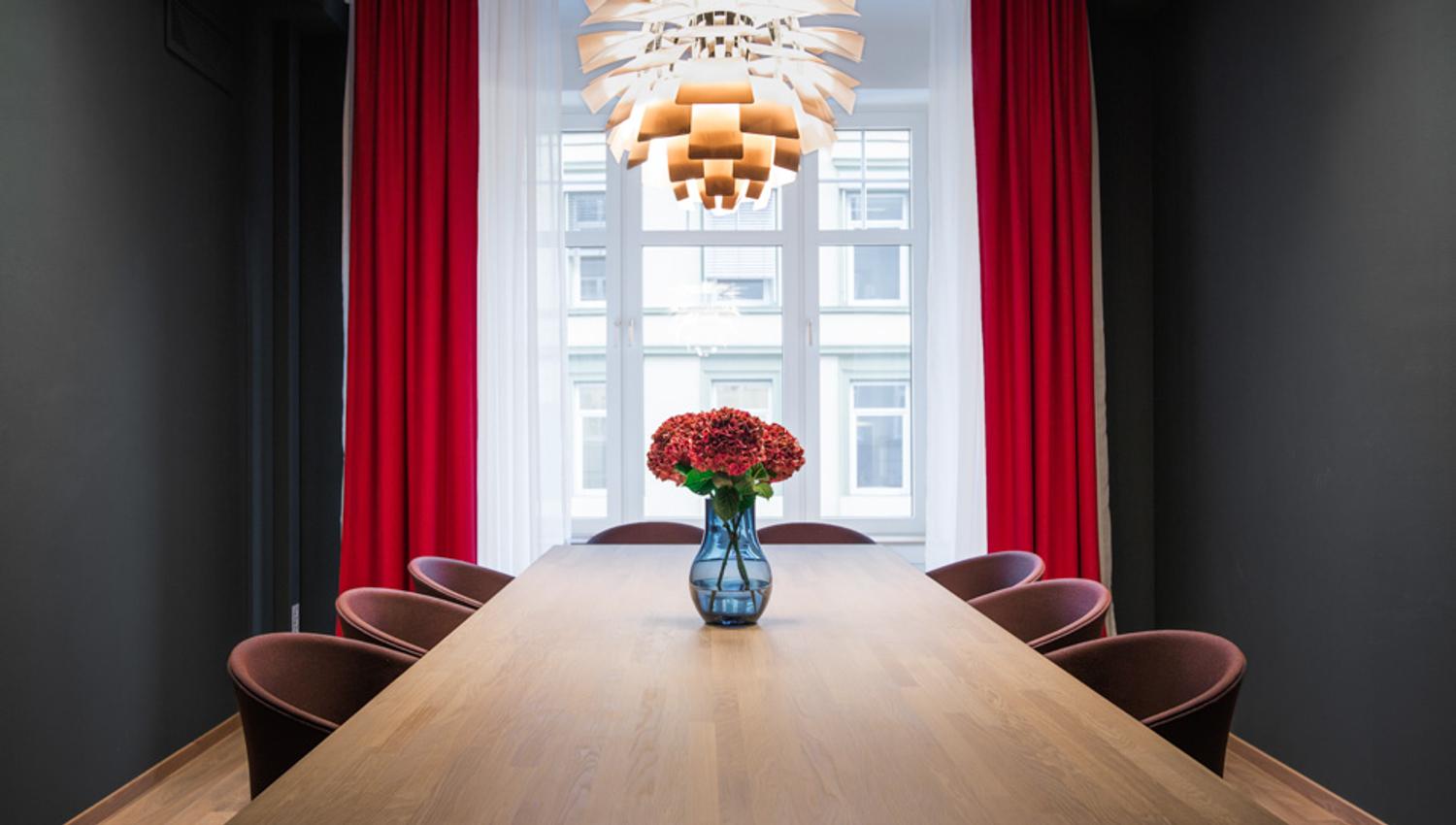 Meeting room with eight chairs. Red curtains, red flowers. Hotell Bondeheimen, Oslo. Photo