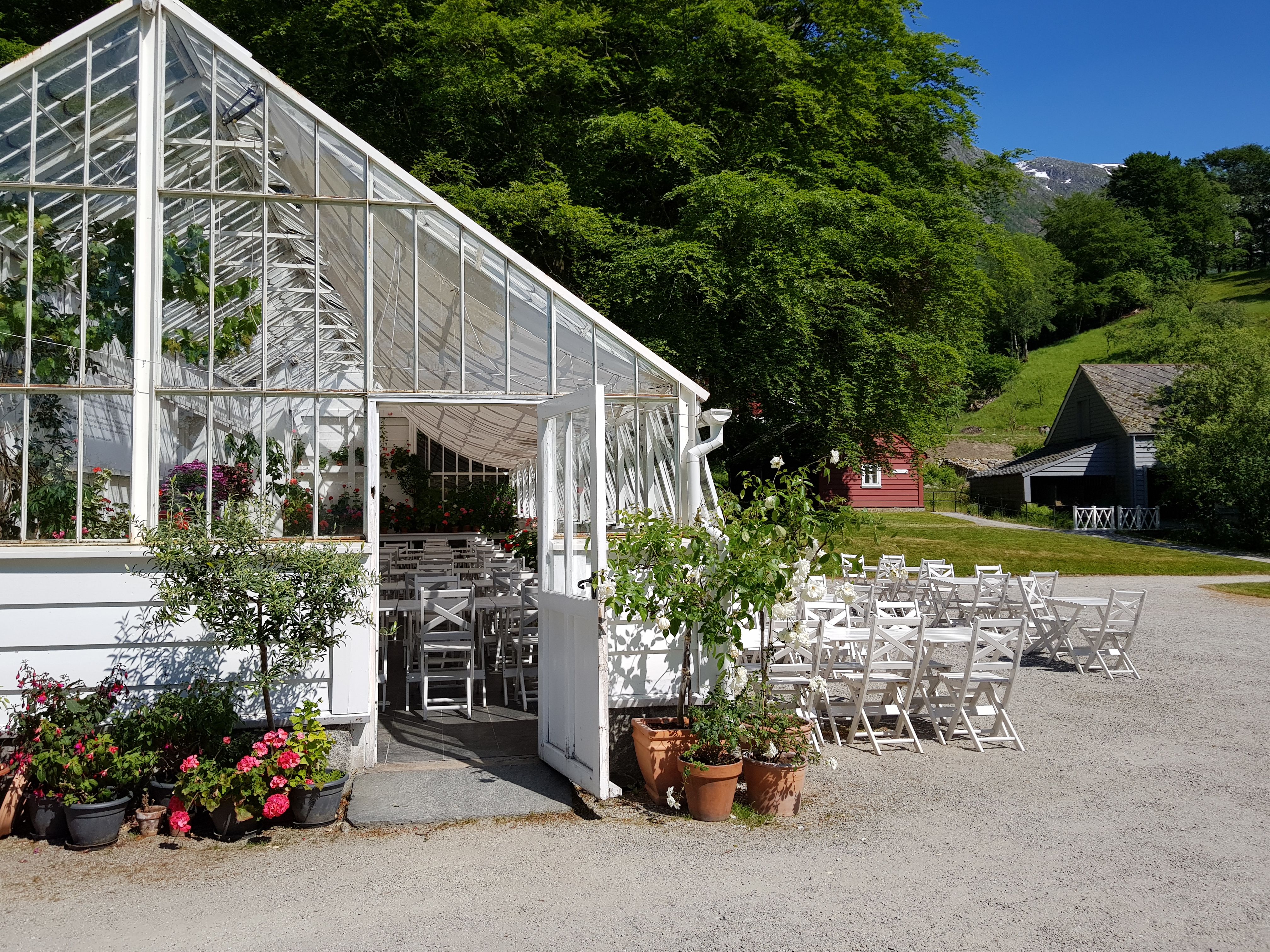 Drivhus med servering og sitjeplassar i Baroniet Rosendal sin hage.