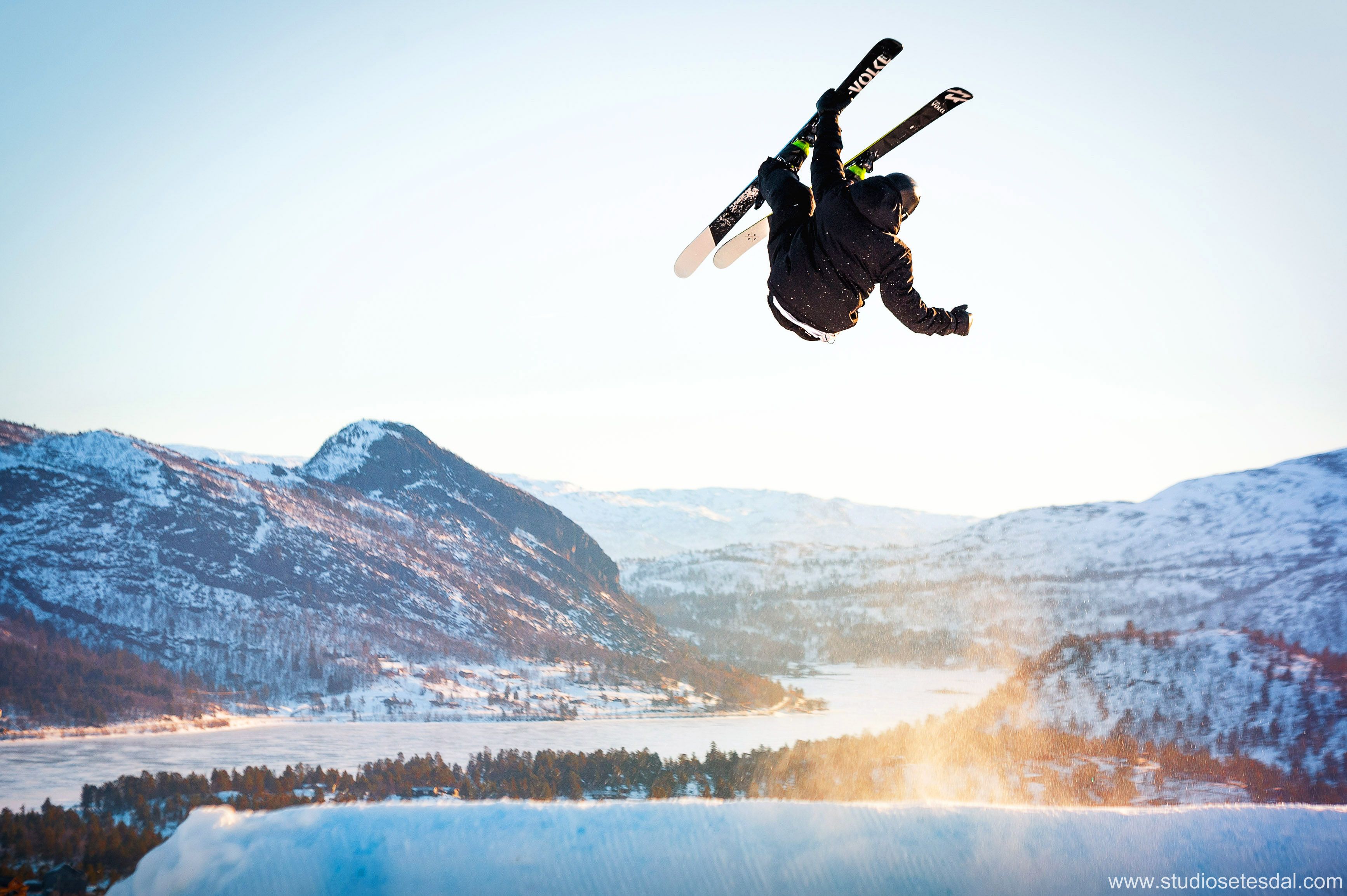 Gutt på ski flyr høyt, med utsikt over Hovden, bilde