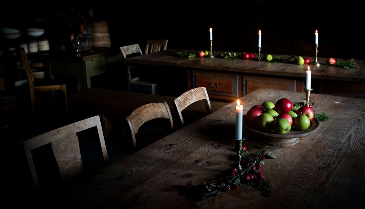 Koselig interiør med epler og levande lys på Helleland Gard.