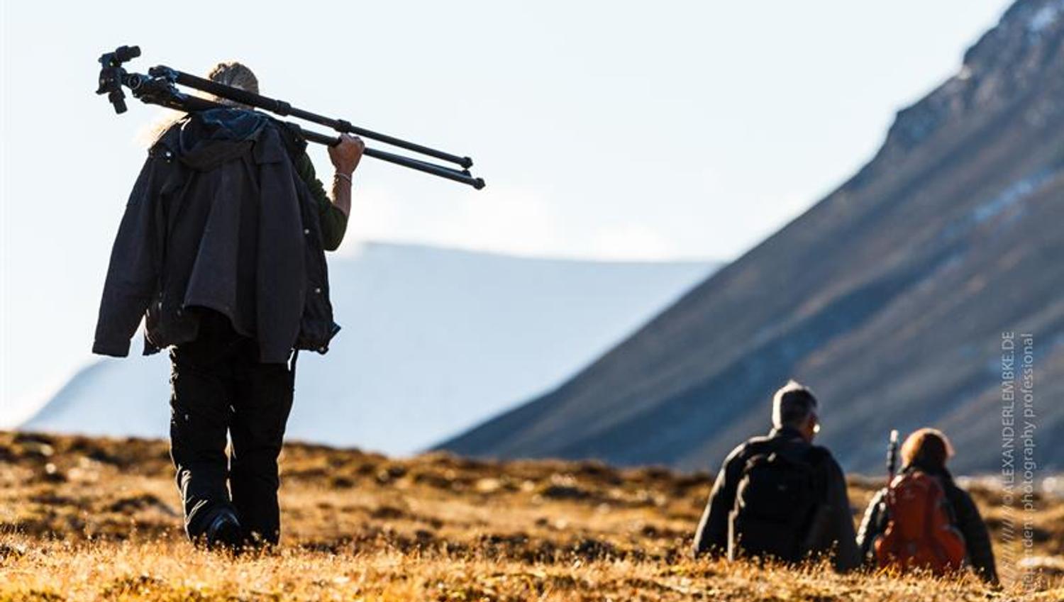 Three people hiking and carrying photoequipment